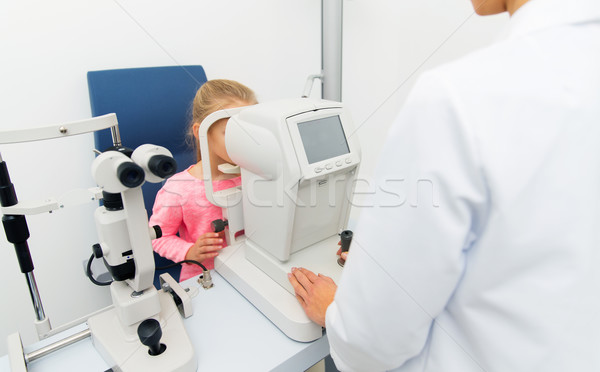 optician with autorefractor and kid at eye clinic Stock photo © dolgachov