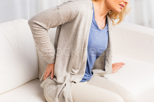 Stock photo: close up of woman suffering from backache at home