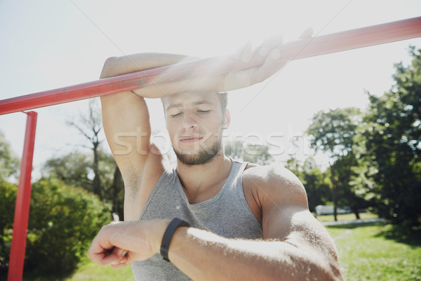man with heart-rate watch exercising outdoors Stock photo © dolgachov