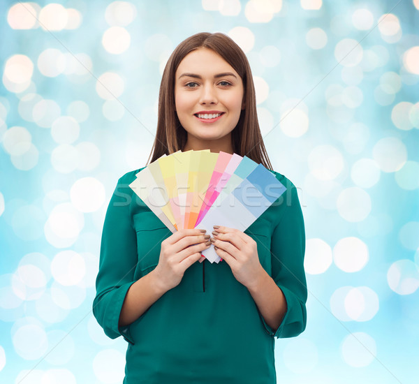 smiling young woman with color swatches Stock photo © dolgachov