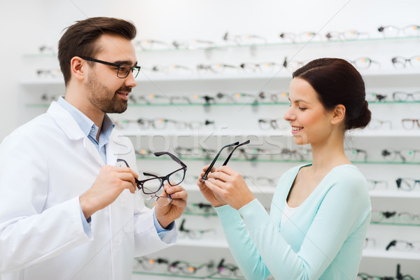 Stock photo: woman and optician showing glasses at optics store