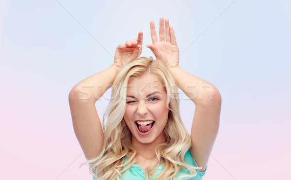 happy smiling young woman making bunny ears Stock photo © dolgachov