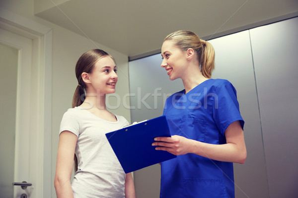smiling nurse with clipboard and girl at hospital Stock photo © dolgachov