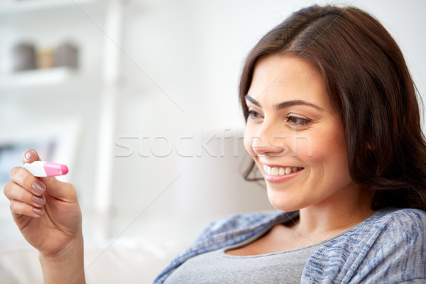 happy woman looking at home pregnancy test  Stock photo © dolgachov