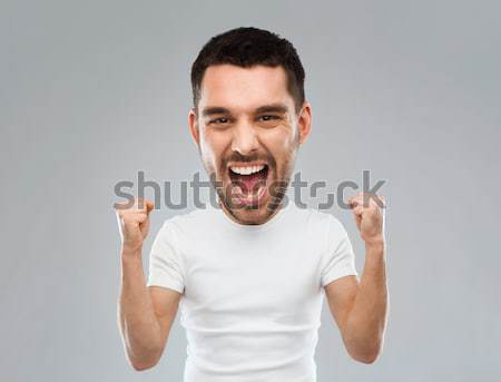 Stock photo: young man celebrating victory over gray