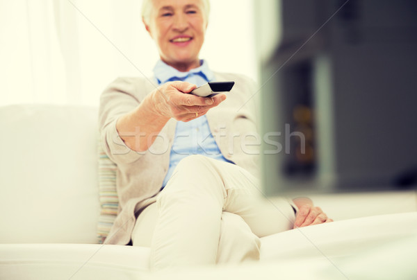 close up of happy senior woman watching tv at home Stock photo © dolgachov
