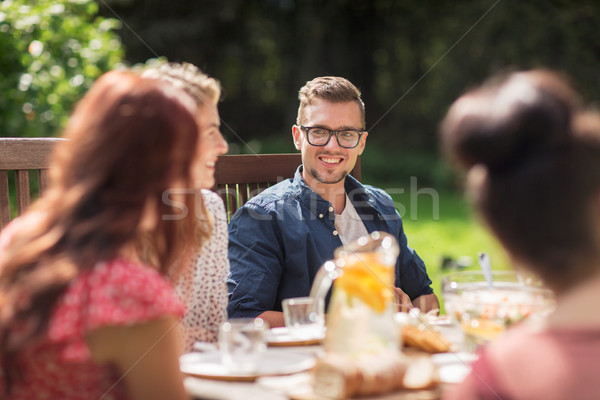 Stock photo: happy friends having dinner at summer garden party