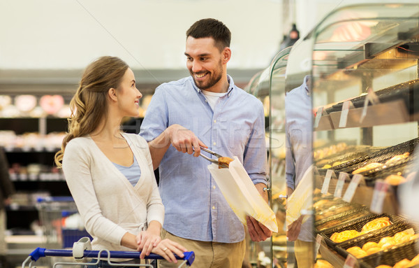 happy couple with shopping cart at grocery store Stock photo © dolgachov