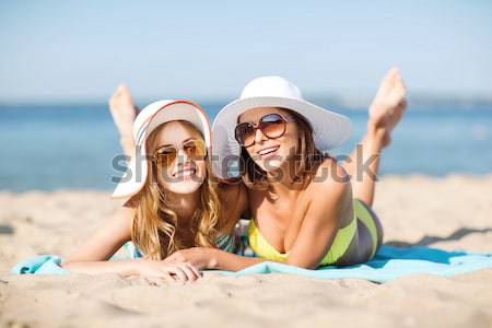 Boldog nők napozás székek nyár tengerpart Stock fotó © dolgachov
