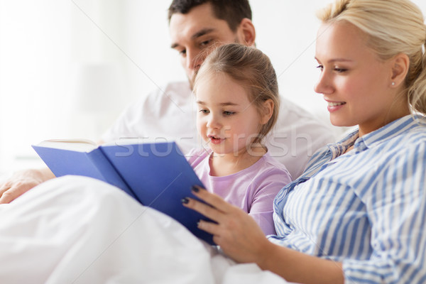 Famille heureuse lecture livre lit maison personnes [[stock_photo]] © dolgachov