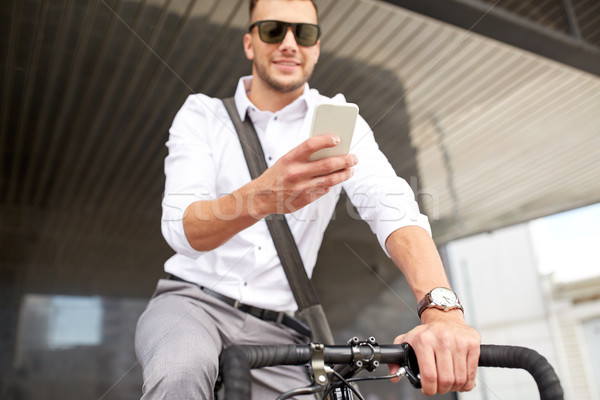 Stock photo: man with smartphone and fixed gear bike on street