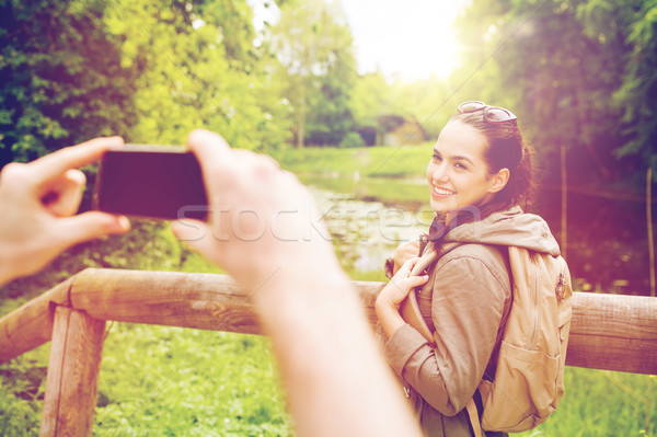 couple with backpacks taking picture by smartphone Stock photo © dolgachov