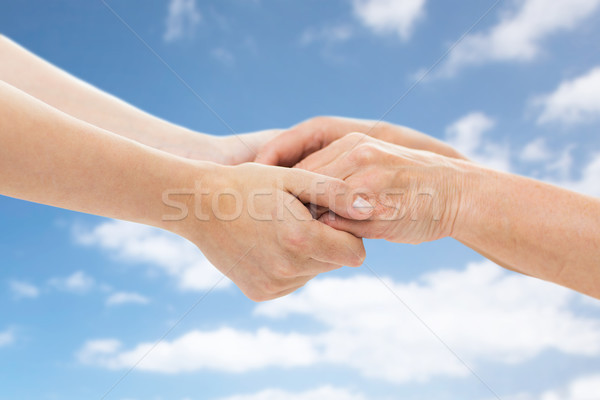 close up of senior and young woman holding hands Stock photo © dolgachov