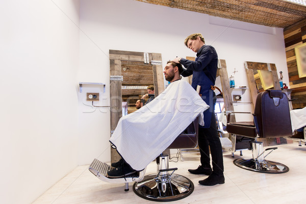 man and barber cutting hair at barbershop Stock photo © dolgachov