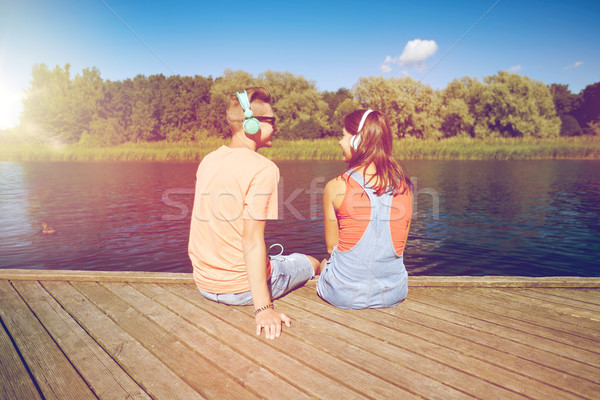 teenage couple with headphones on river berth Stock photo © dolgachov