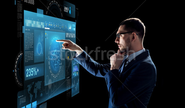 businessman with virtual screen over black Stock photo © dolgachov
