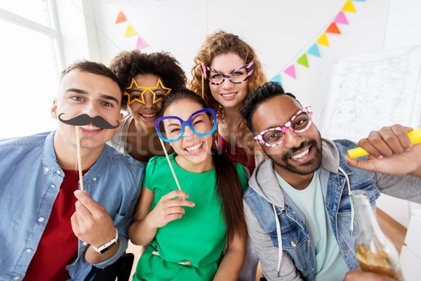 happy friends or team having fun at office party Stock photo © dolgachov