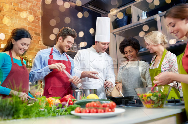 Stock photo: happy friends and chef cook cooking in kitchen