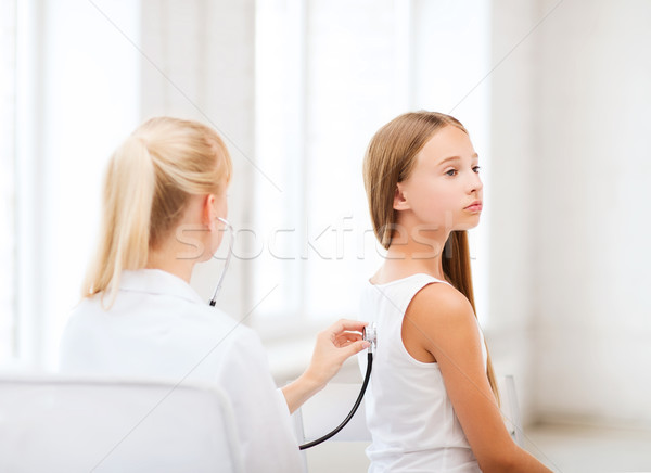 doctor with stethoscope listening to the patient Stock photo © dolgachov