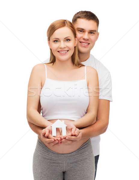 Stock photo: happy young family expecting child with house