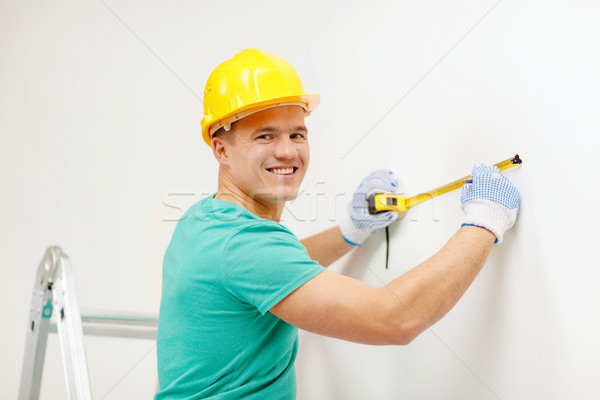 Sonriendo hombre casco pared reparación Foto stock © dolgachov