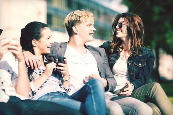 students looking at smartphones and tablet pc Stock photo © dolgachov