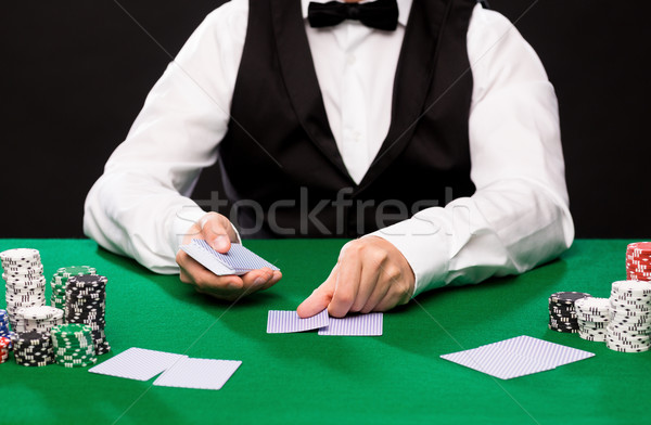 holdem dealer with playing cards and casino chips Stock photo © dolgachov
