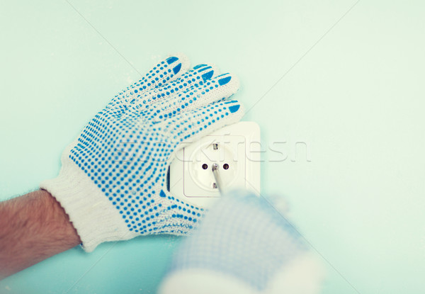 close up of male in gloves installing new socket Stock photo © dolgachov