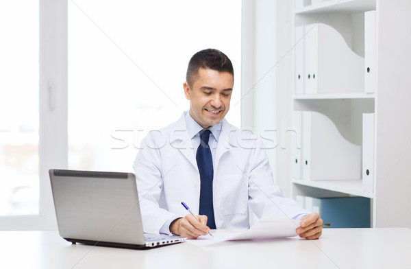 smiling male doctor with laptop in medical office Stock photo © dolgachov
