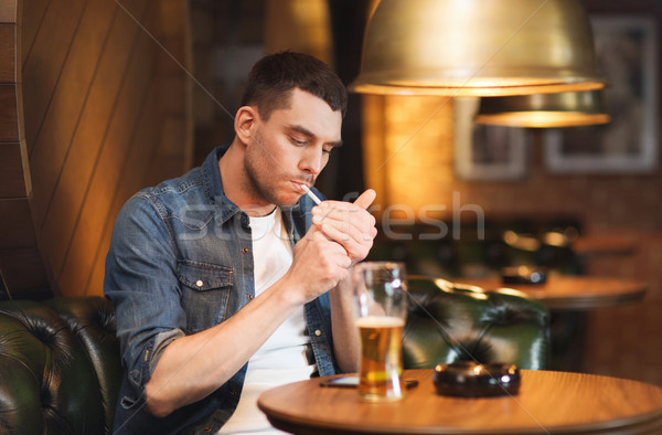 Homem potável cerveja fumador cigarro bar Foto stock © dolgachov