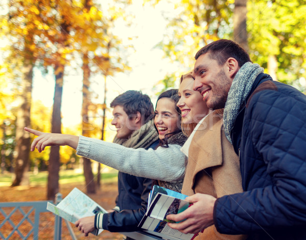 group of friends with map outdoors Stock photo © dolgachov