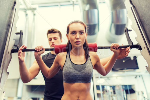 man and woman with barbell flexing muscles in gym Stock photo © dolgachov
