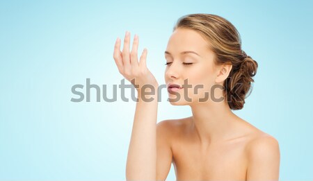 woman smelling perfume from wrist of her hand Stock photo © dolgachov