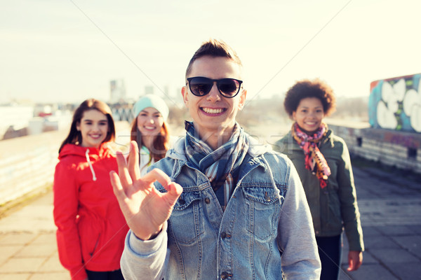 Stock photo: happy teenage friends showing ok sign on street