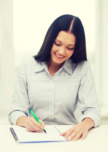 smiling businesswoman or student studying Stock photo © dolgachov