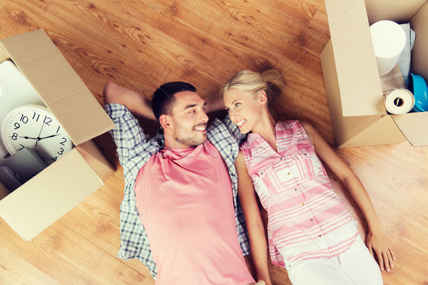 happy couple lying on floor among cardboard boxes Stock photo © dolgachov