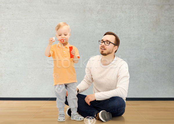 father with son blowing bubbles and having fun Stock photo © dolgachov