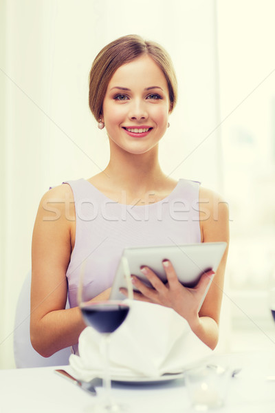 smiling woman with tablet pc computer at resturant Stock photo © dolgachov