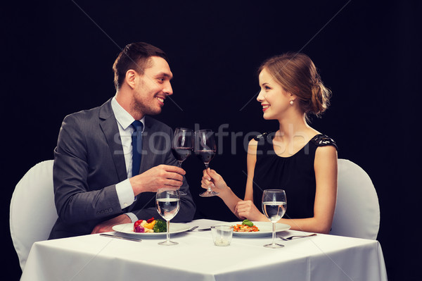 smiling couple eating main course at restaurant Stock photo © dolgachov