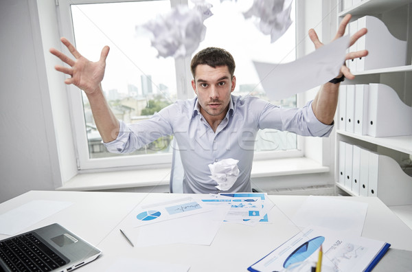 angry businessman throwing papers in office Stock photo © dolgachov