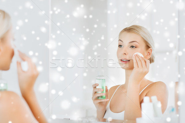 young woman with lotion washing face at bathroom Stock photo © dolgachov