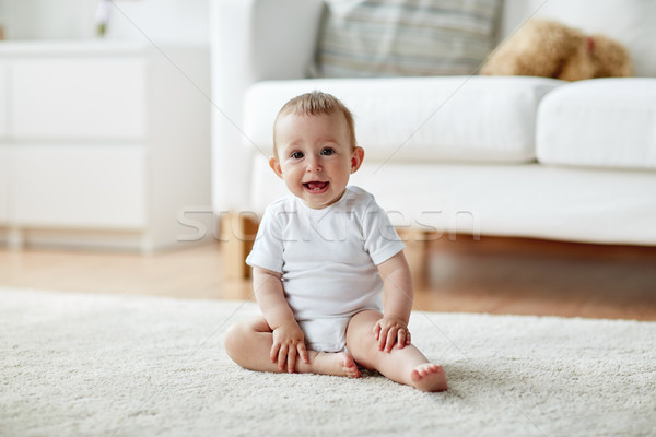 happy baby boy or girl sitting on floor at home Stock photo © dolgachov