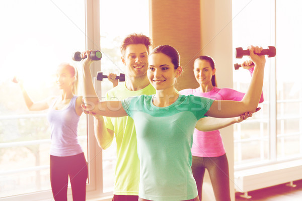 group of smiling people exercising with dumbbells Stock photo © dolgachov