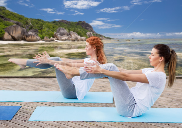 women making yoga in half-boat pose outdoors Stock photo © dolgachov