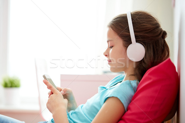 Happy girl smartphone słuchawki domu dzieci technologii Zdjęcia stock © dolgachov