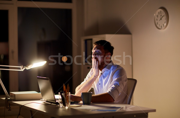 man with laptop and coffee working at night office Stock photo © dolgachov