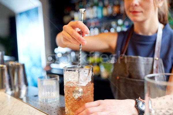 bartender with cocktail stirrer and glass at bar Stock photo © dolgachov