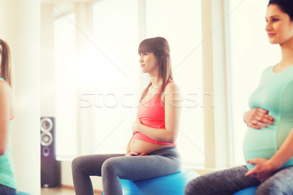 happy pregnant women exercising on fitball in gym Stock photo © dolgachov