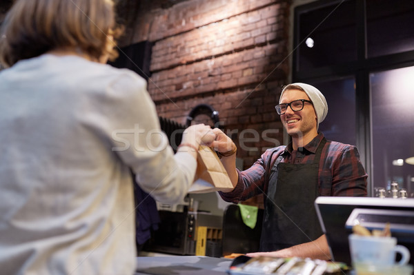 Stock photo: woman taking paper bag from seller at cafe
