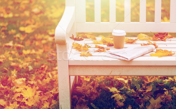 newspaper and coffee cup on bench in autumn park Stock photo © dolgachov